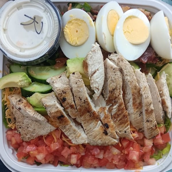Chefhouse grilled chicken salad with hard-boiled eggs, avocado, cucumber, and diced tomatoes.
