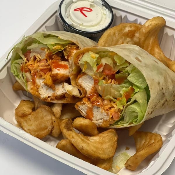 Chefhouse buffalo chicken wrap with lettuce, cheese, tomatoes, and curly fries, served with ranch.